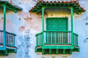 a small covered green balcony with green doors in Havana Cuba