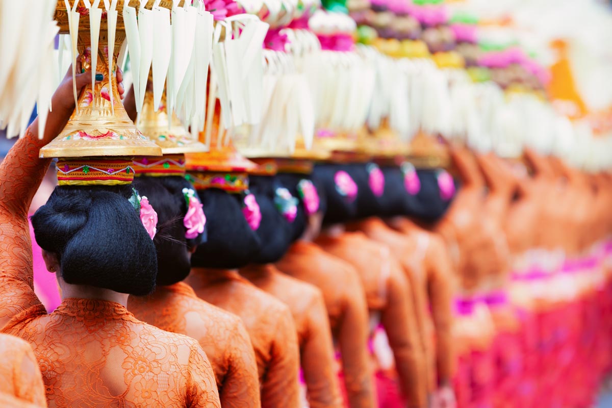 INDONESIA Balinese women in costumes sarong carry offering for hindu ceremony